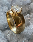 A side view of the 14k yellow gold ring with a prong-set hexagon diamond, showing off the thickness of the band, with a crystal background.