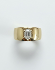 Thick 14k yellow gold ring, with a prong set hexagon diamond against a white background