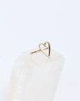 Solid 14k yellow gold halo heart outline diamond ring in size 6, on a quartz gemstone. This side view shows the thin band going around the sides of the heart.