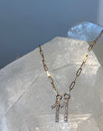 11 diamond pendant on a solid 14k gold paperclip chain, set against a white quartz crystal.