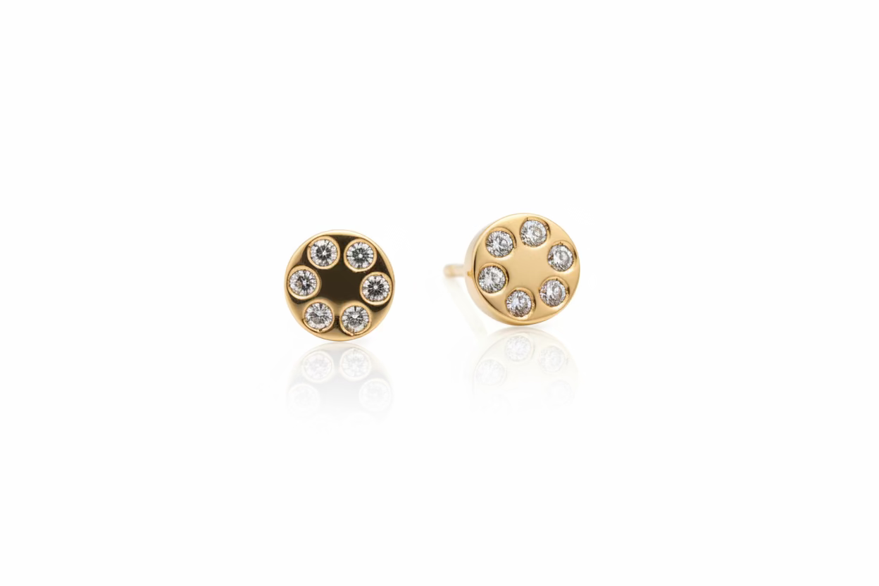 Pair of 14k yellow gold earrings with six diamonds with a white background. 