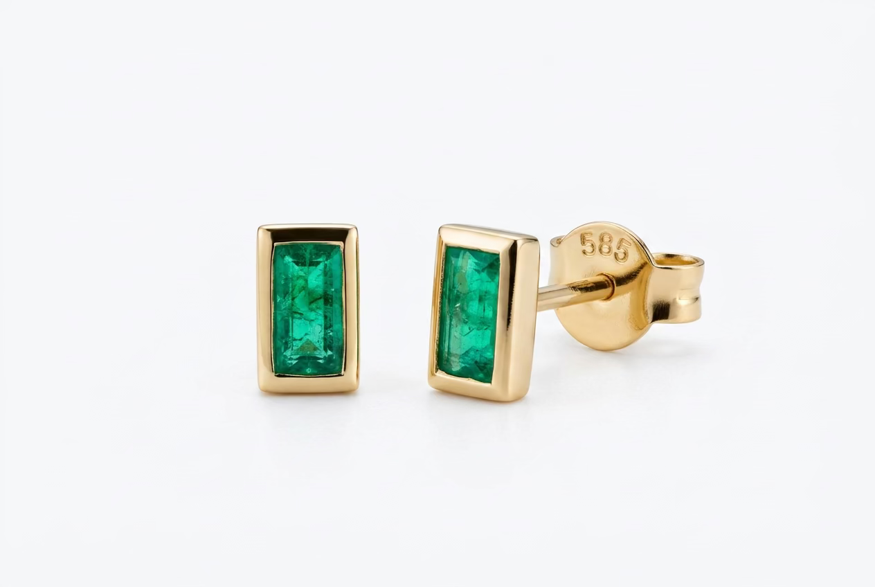 Solid 24k Gold stud earrings with a 585 stamp. Each emerald is an emerald cut, and in a 14k gold bezel setting, with a post back 