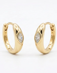 Solid 14k yellow gold huggies, with a bezel set marquise diamond, against a white background.