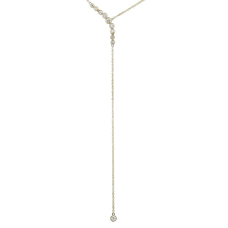 Delicate 14k yellow gold y-shaped necklace with asymmetrical gradient diamond drop, and a cable chain with a bezel set diamond at the bottom. Set against a white background.