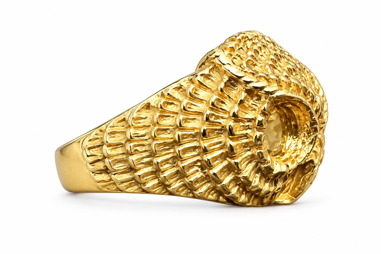 A side view of the Athena owl ring, showing off the feather detailing going around the sides, as well as the feathered eye feature. Against an amethyst crystal background. 