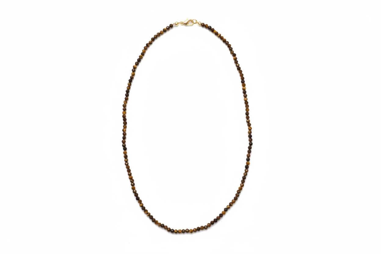 A beaded necklace made of small dark brown Tiger's Eye beads with a gold-filled clasp, laid out on a white background. 