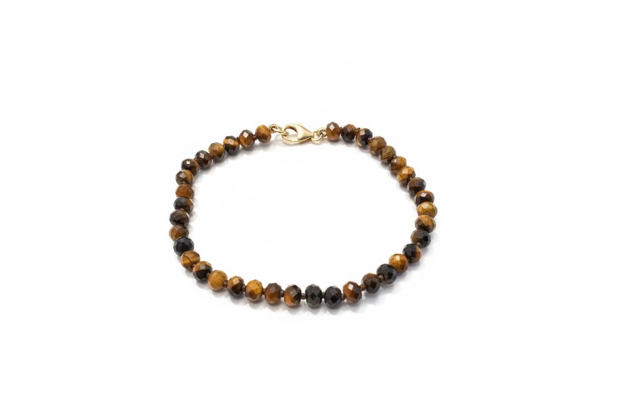 A 6 inch hand-beaded bracelet. Featuring brown and black Tiger's Eye beads with a small gold-filled clasp, against a white background. 