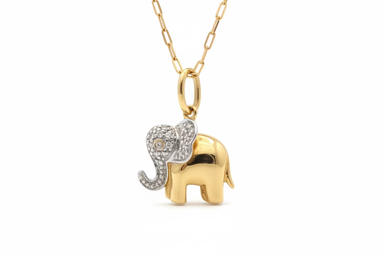 14k gold elephant pendant with pave diamonds on a paperclip chain with a white background