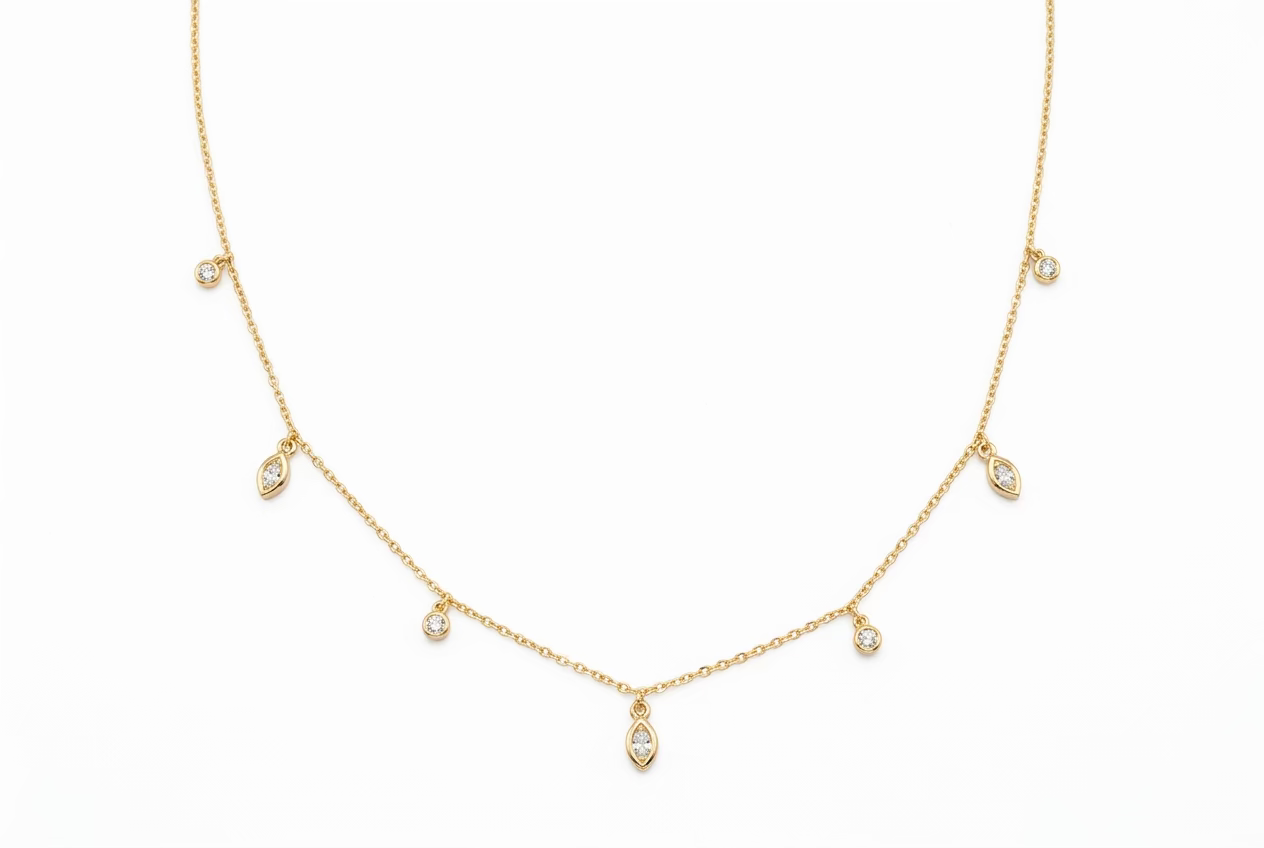 A gold vermeil lariat necklace with alternating marquise and brilliant cut cubic zirconia in a bezel setting, against a white background.