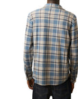 The back of a man wearing a Faherty Legend Sweater Shirt in Overcast Ocean Plaid with blue, grey, and beige plaid shirt on a white background. 