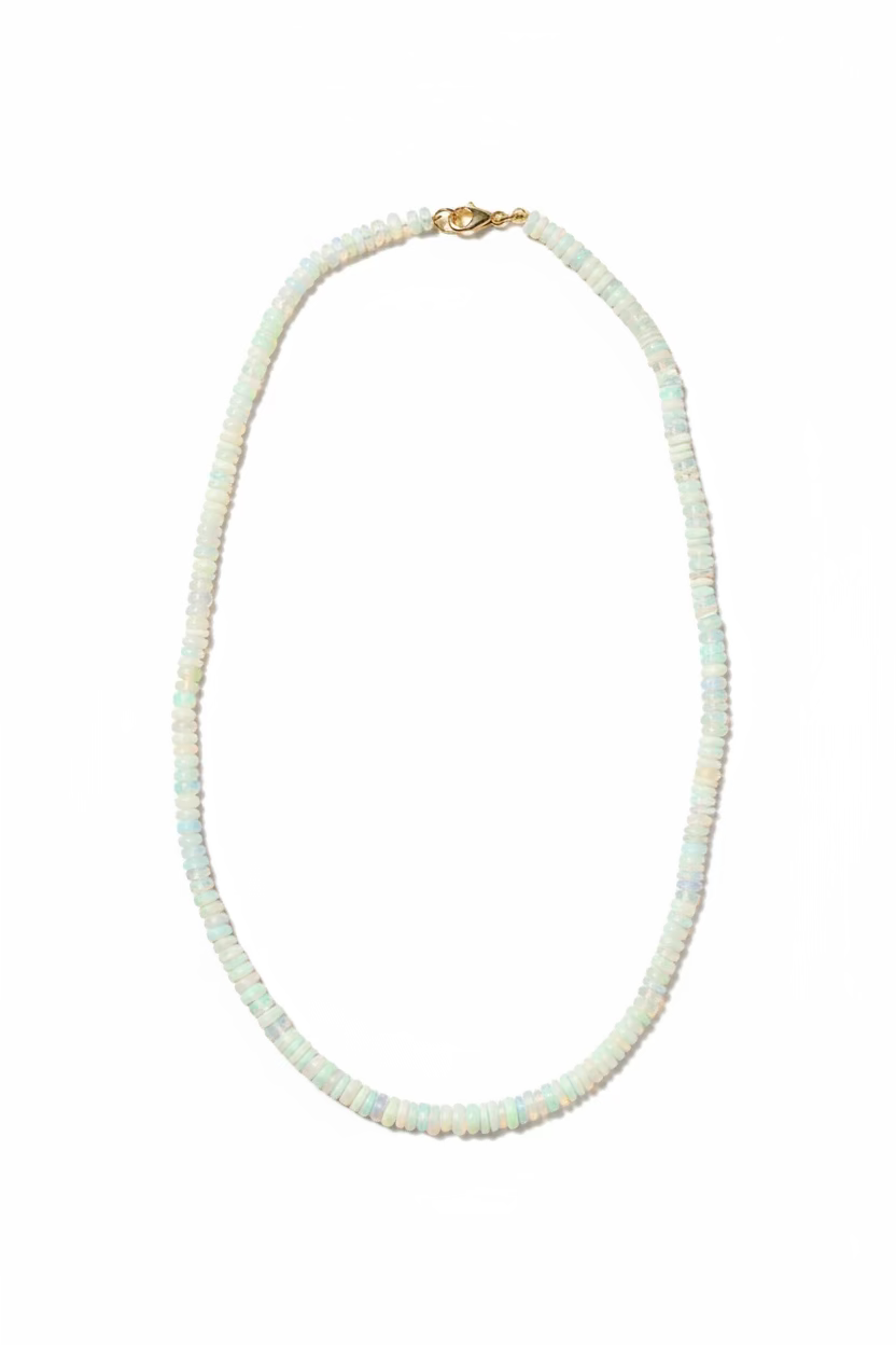 A hand beaded necklace made of small iridescent white opals with a gold-filled clasp, with a white backgound.