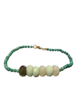 A beaded bracelet with turquoise green beads and six large pale green chrysoprase stone beads in the center, displayed against a white background.