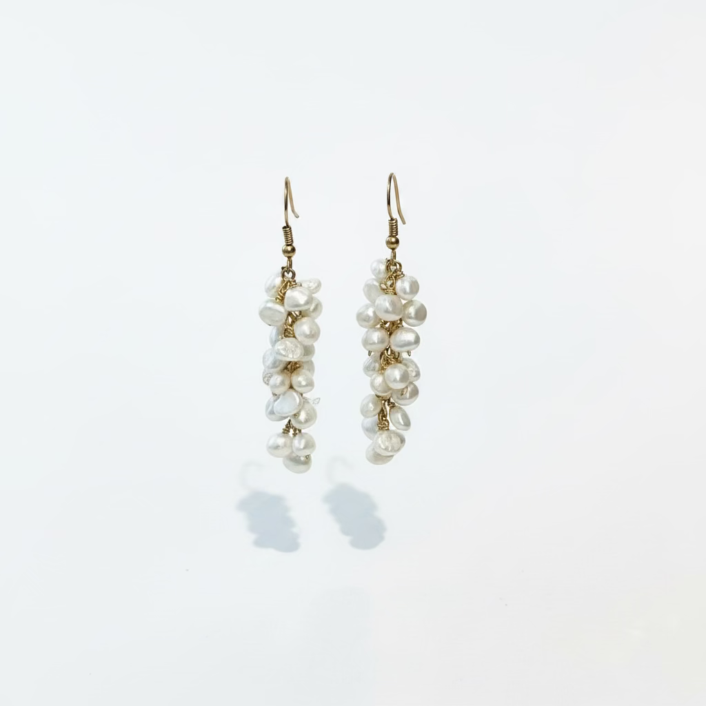 A pair of wire-wrapped fresh water pearl earrings displayed against a white background
