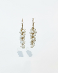 A pair of wire-wrapped fresh water pearl earrings displayed against a white background