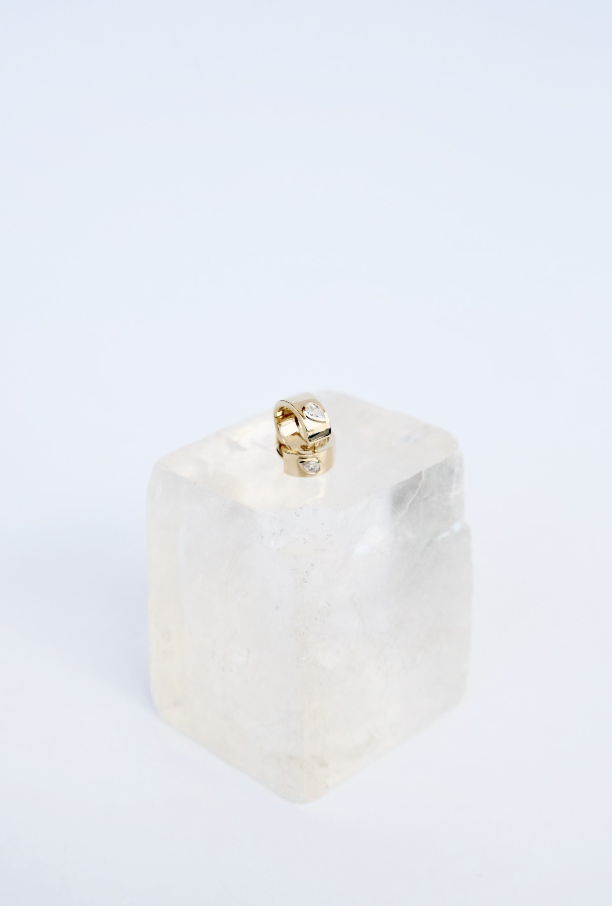 Teardrop Huggies pave set (peat-shape) diamond on wide 14k  yellow gold band.