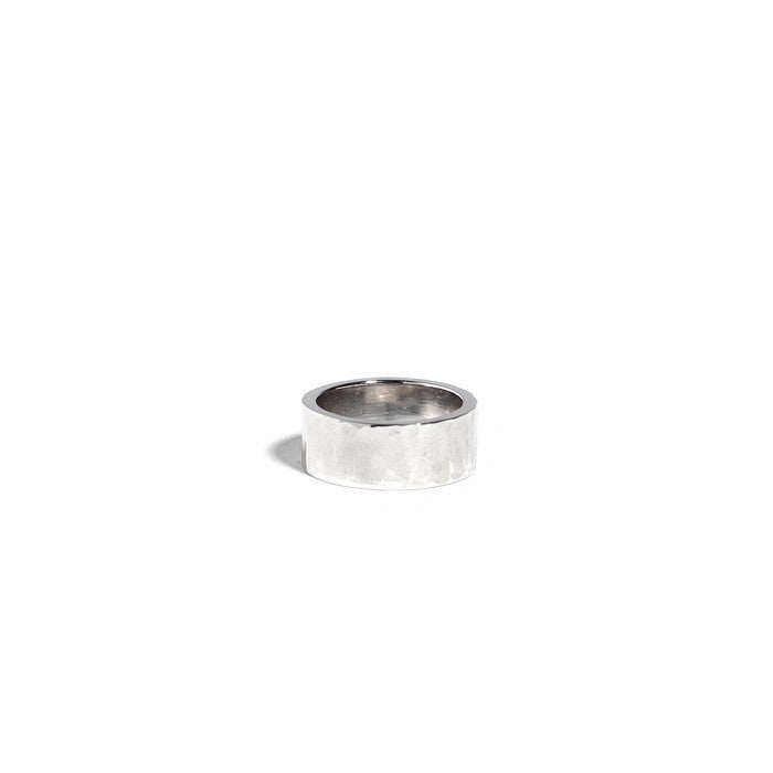 A silver hammered cigar band against a white background. 